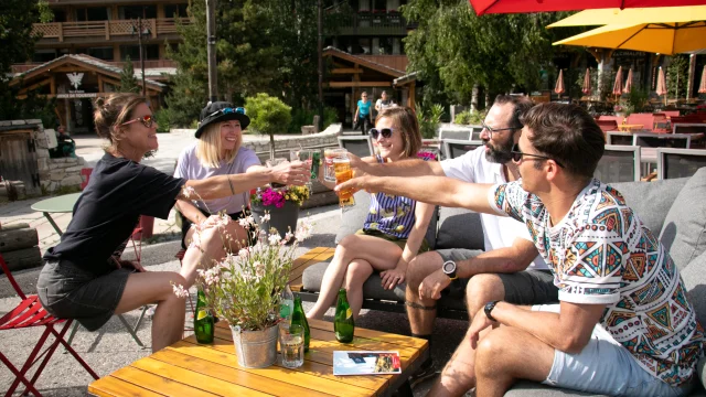 Enjoy a drink with friends on the Tourist Office square in Val d'Isère in summer